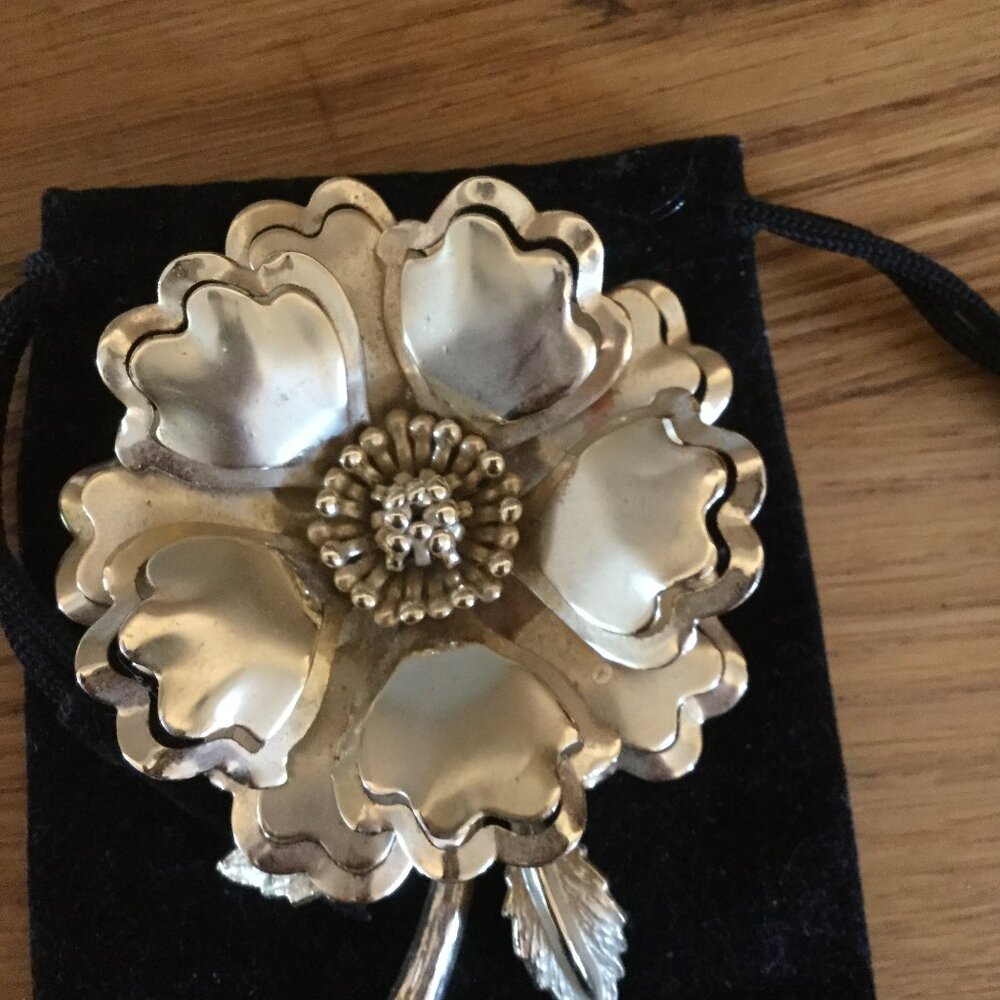 Gold tone flower brooch  comes with black pouch measures 3.5"x 2"